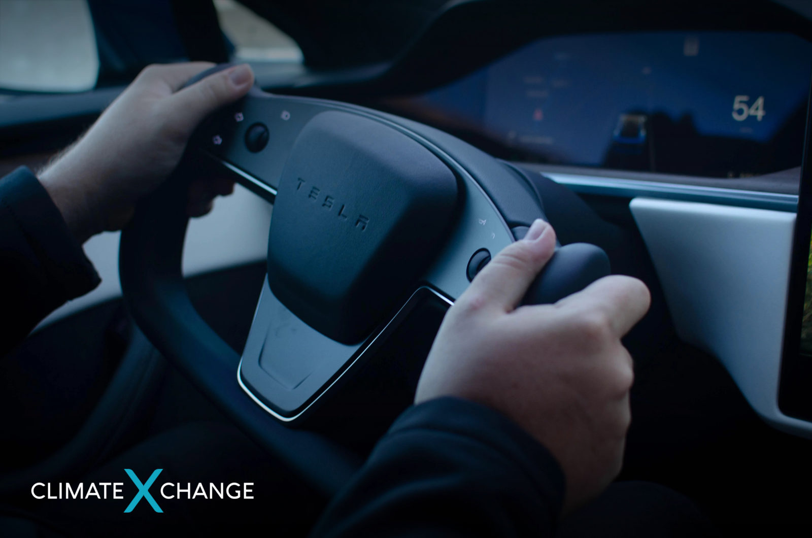 Hands on a steering wheel in a Tesla electric car