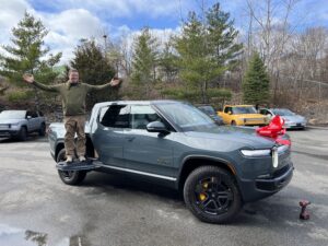 Raffle winner standing on top of Rivian R1T